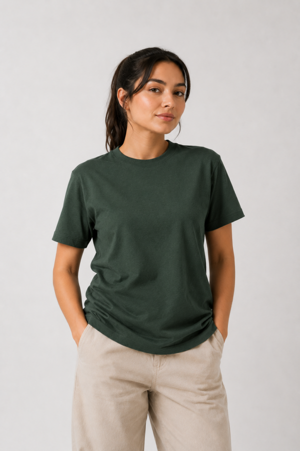 A female model posing with hands in her pockets wearing the stylish lightweight forest green t-shirt.